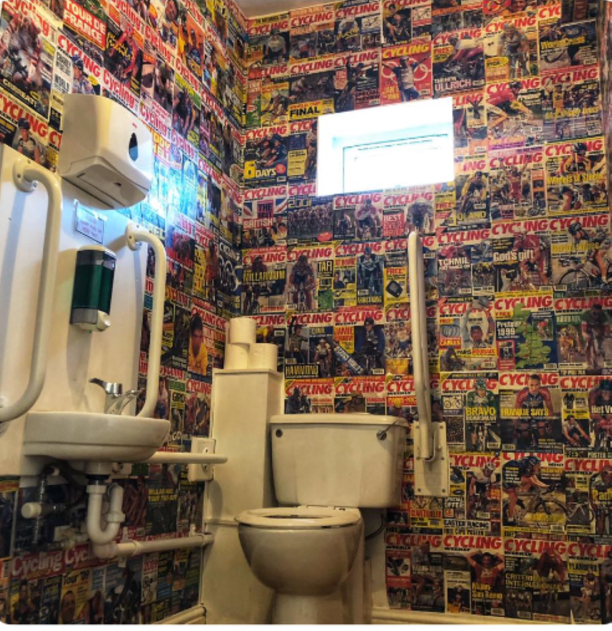 A toilet in a cafe the walls of which have been decorated with magazine pictures