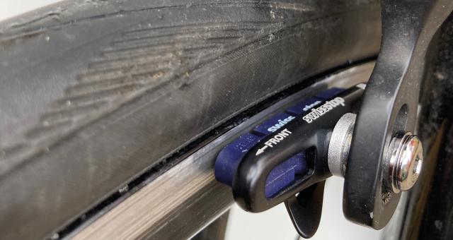 A close-up of a brake pad and shoe in Shimano sidepull callipers