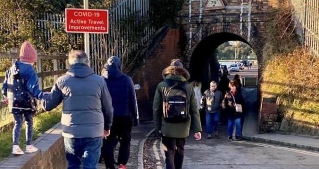 Pedestrians waiting to pass under keyhole bridge after it reopened to traffic