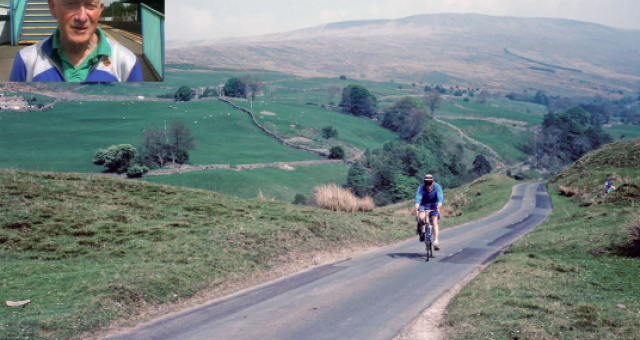A vintage colour photograph of a man wearing blue cycling in a scenic landscape