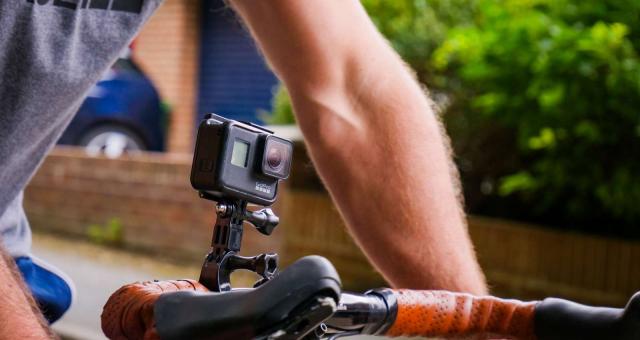 A cyclist using a camera mounted on their handlebars