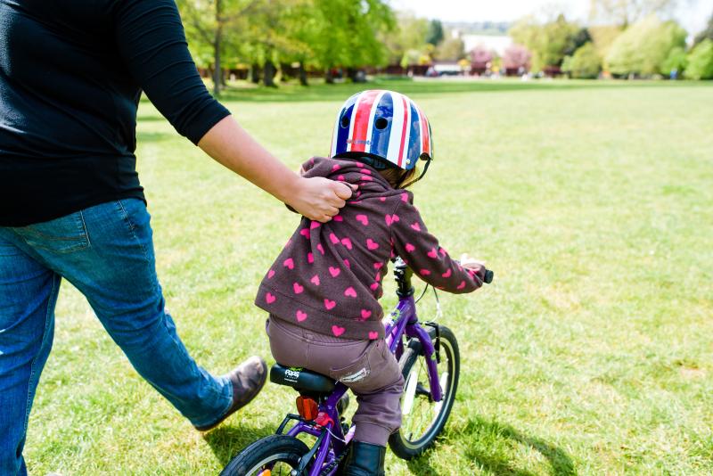 Lightly holding the back of a child's jumper can help them to learn to cycle