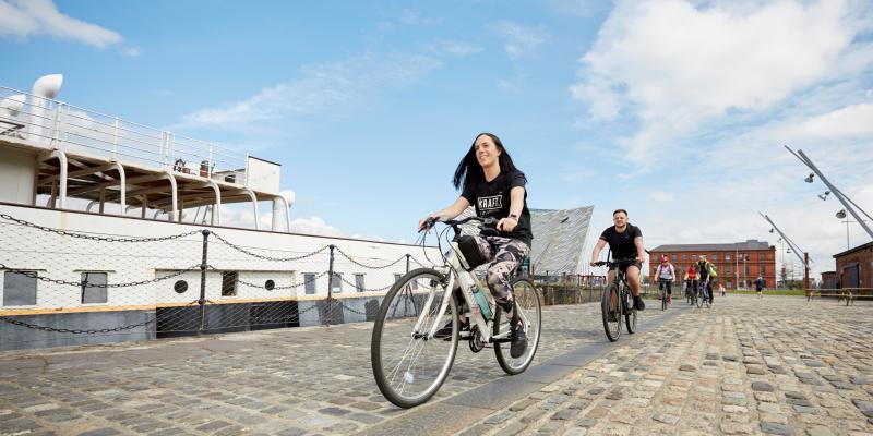 Woman cycles past SS Nomadic ship in Belfast