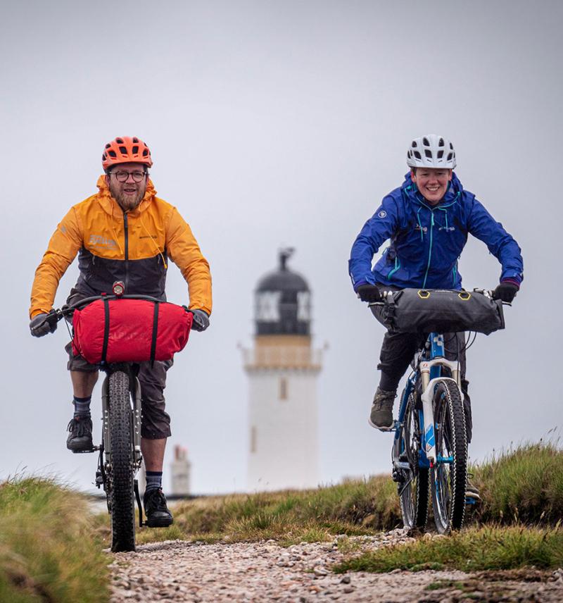 Cyclist riding from the light house at Cape Wrath