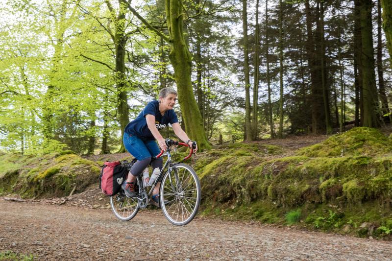 Woman cycling along forest track
