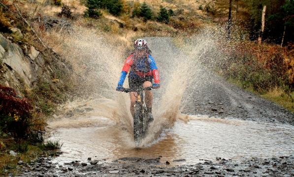Mountain biker splashing through a stream