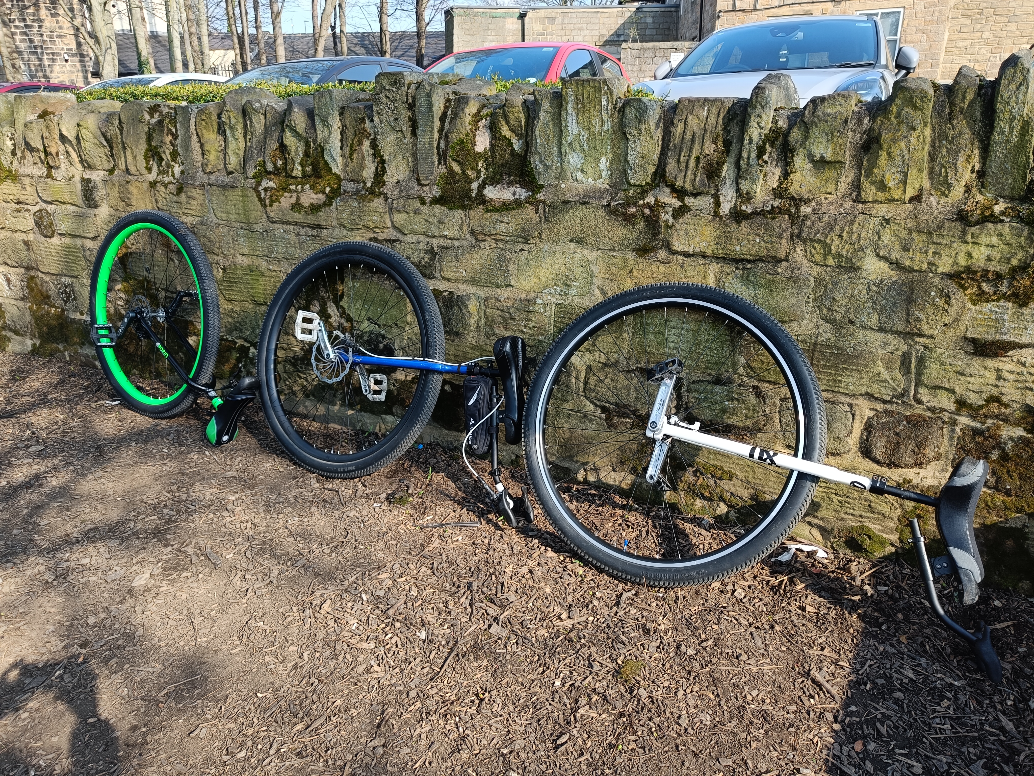 Three 36&quot; unicycles resting against a wall