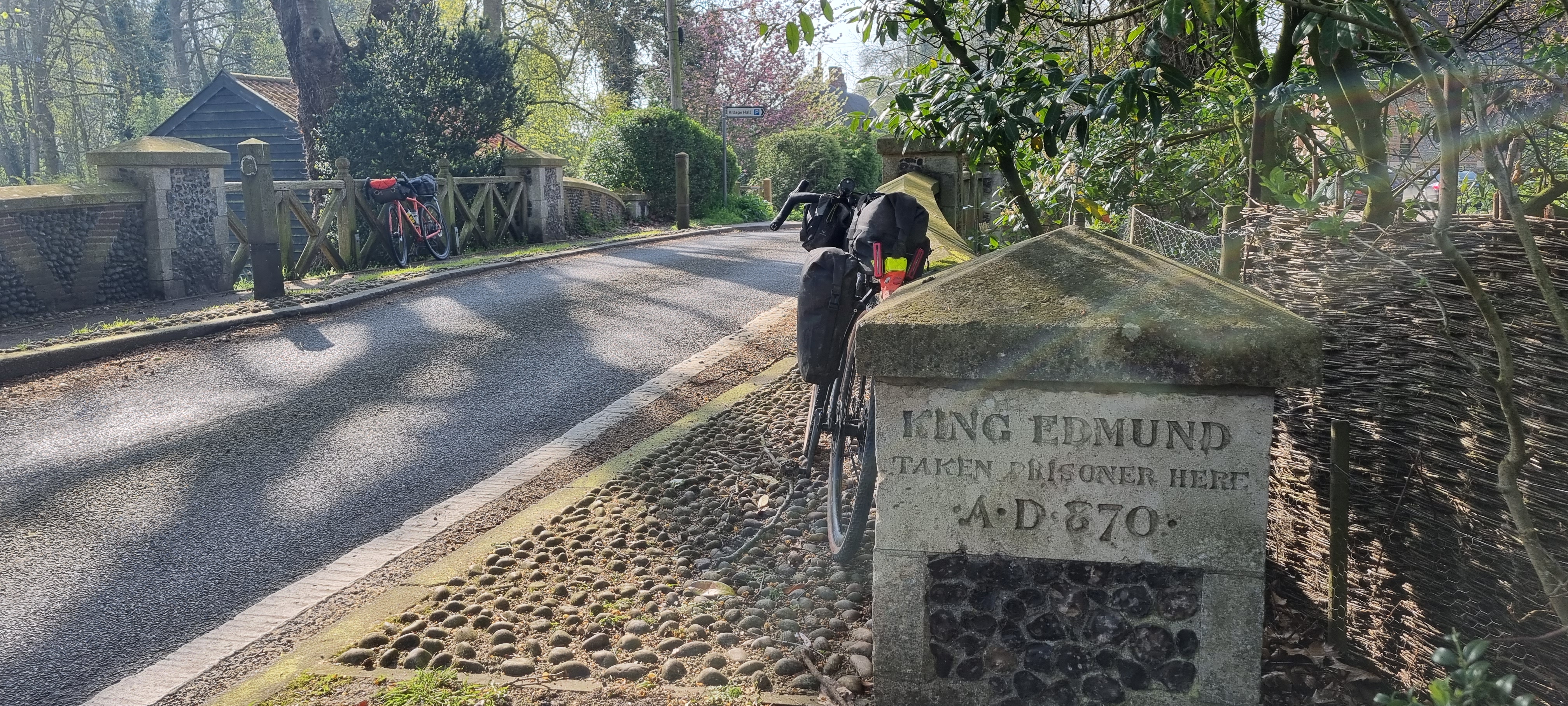 Bike propped against a stone engraved with the words "King Edmund taken prisoner here A.D. 870"