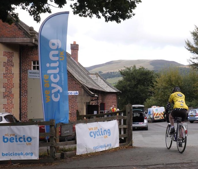 A rider arriving at the village hall for the buffet lunch. Photo by Robby Spanring, Cycling UK