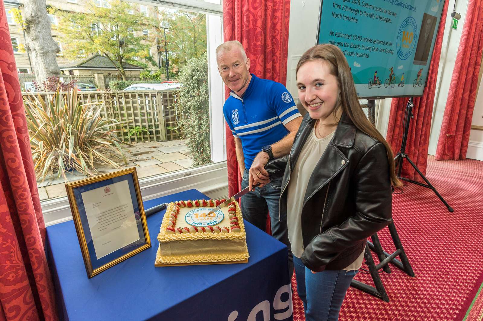 Paul Tuohy and Tourist competition junior winner Sophia Morris cut the birthday cake