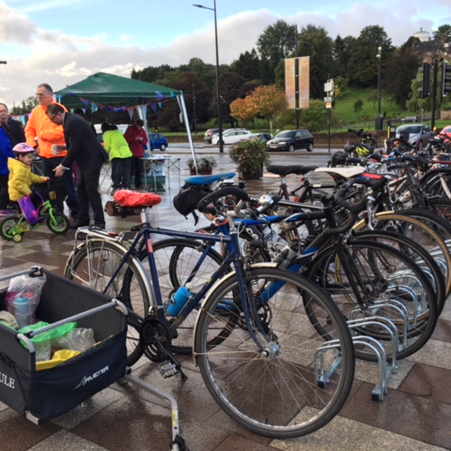 Bikes parked near a gazebo where their riders are enjoying a free breakfast.