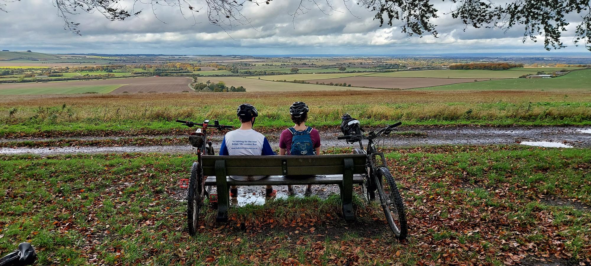 Two cyclist look out from King Alfreds Way sat on a bench