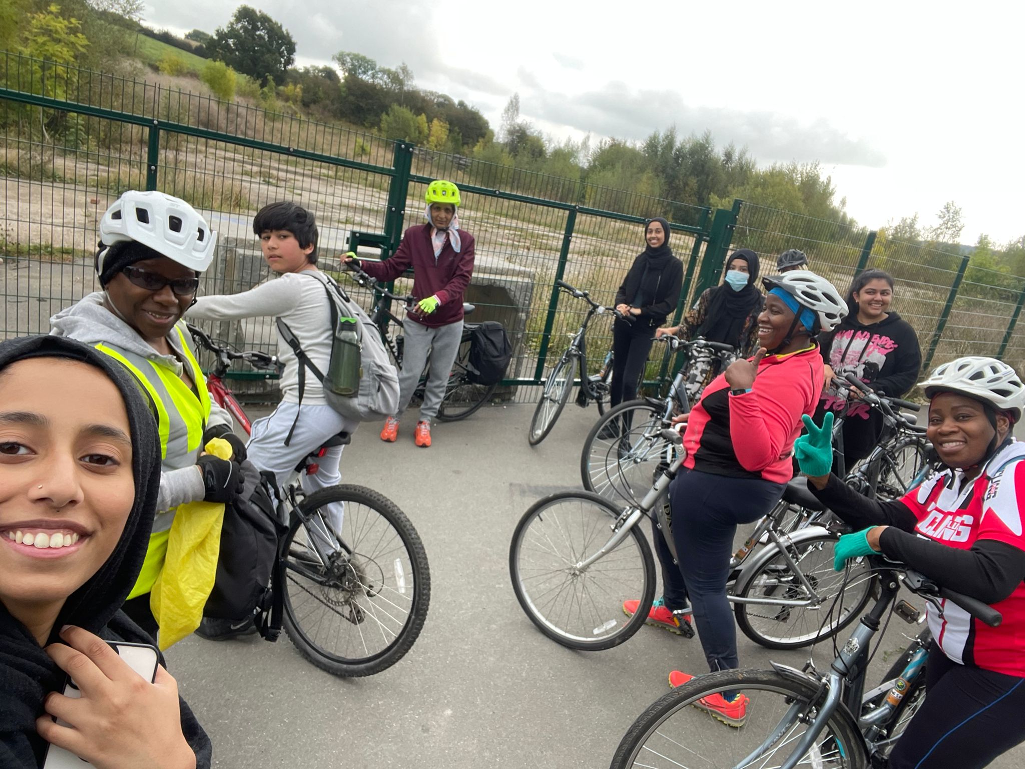 people standing smiling with their bikes on a cycle path