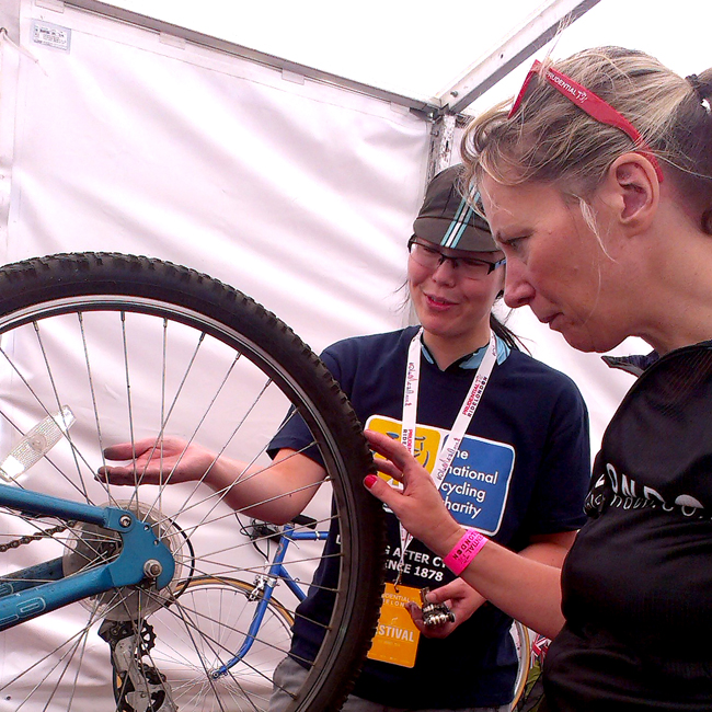 A Dr Bike volunteer fixing a participant's cycle