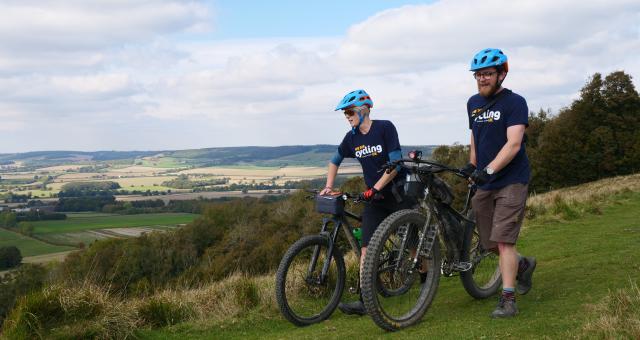 Sam Jones (right, CUK) and Hannah Dobson (Singletrack) walking their bikes towards the Crown on Wye September 30, 2018. The riders were undertaking a recce of Cycling UK's proposed &quot;riders route&quot; of the North Downs Way as part of the 40th anniversary celebrations of the national trail.