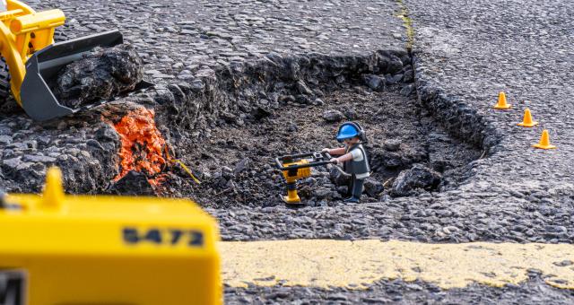 Playmobile construction worker toy placed in a large pot hole (c) Robert Spanring