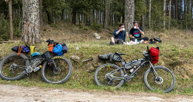 Two cyclists enjoy a break in the Tuscan hills