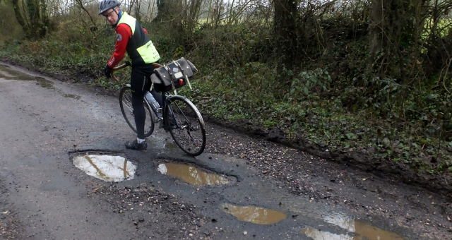 Cyclist by a pothole in Devon