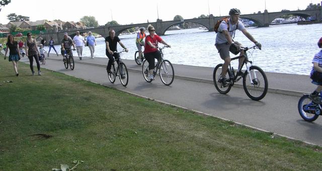 cyclists riding by waterside