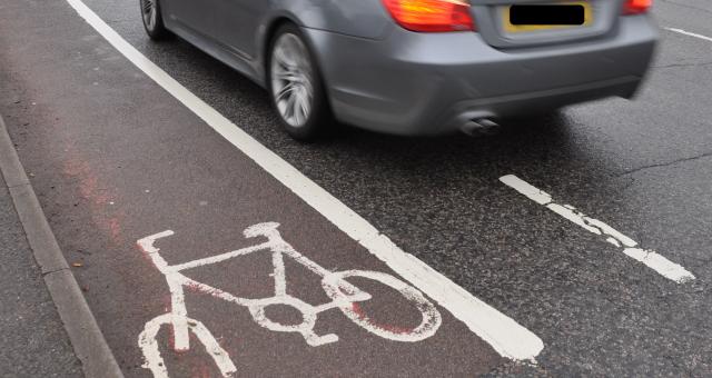 Car driving next to cycle lane