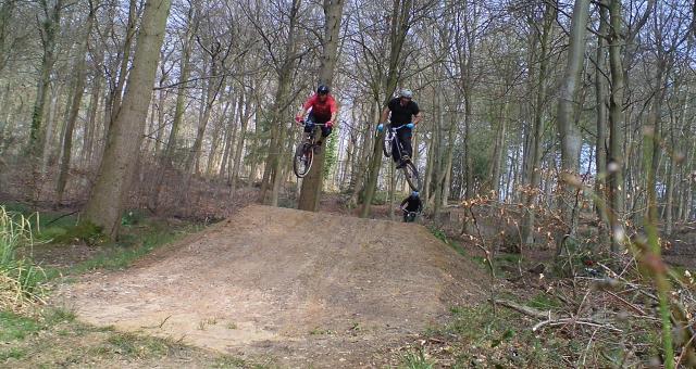 Riders from Bike Park Bishopstoke jumping over a dirt jump