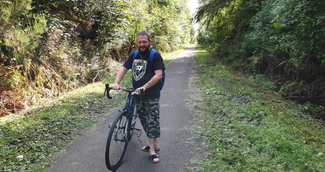 Chris McCann with his bike on a bicycle path