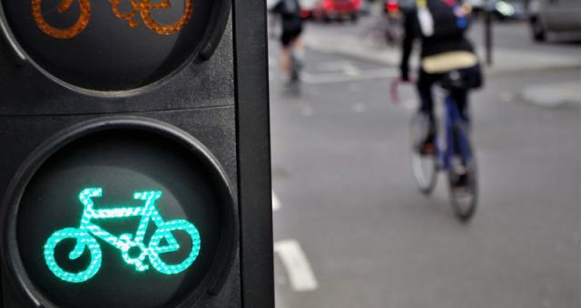 Cycle traffic lights on green with cyclist out of focus in background