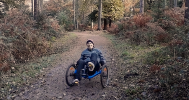 Rider on a trike in the forest.