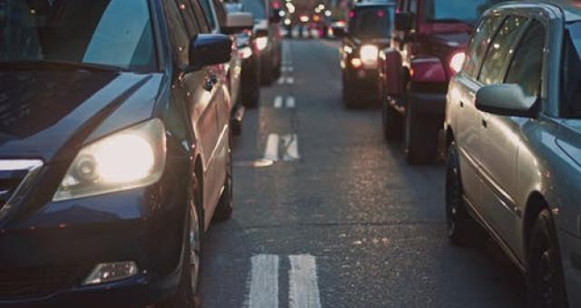 Cars queue in traffic on a road at night