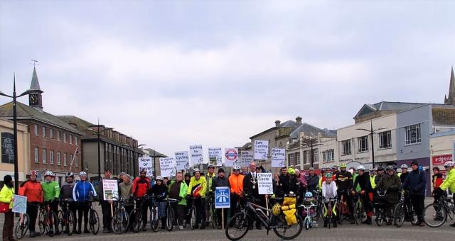 Group of cyclists holding placards