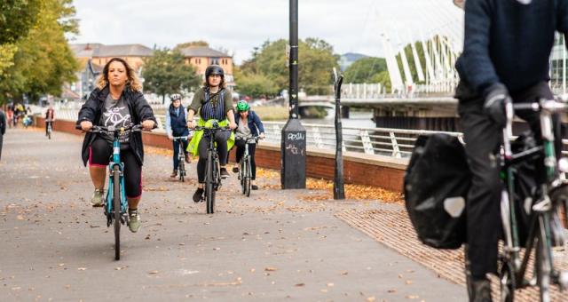 Cyclist ride along a wide path in central Cardiff