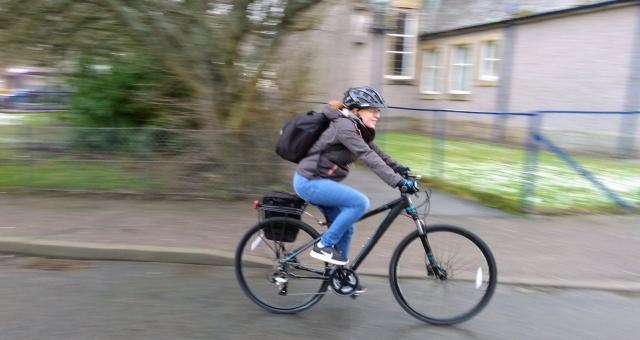 woman in urban area riding bike with blurred background