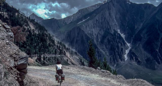 A cyclist heads towards an alpine landscape