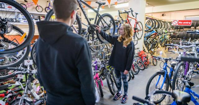 woman in bike shop pointing out bikes to customer