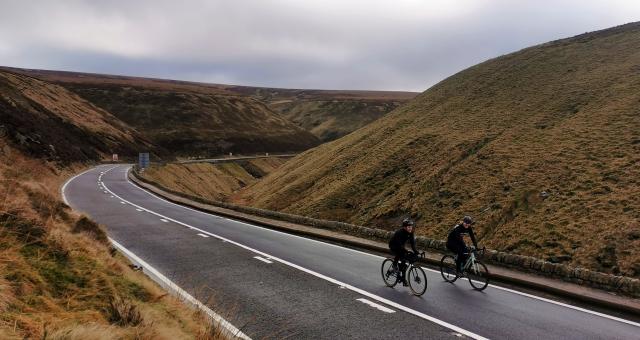 A pair of cyclists ride up the traffic free Snake Pass