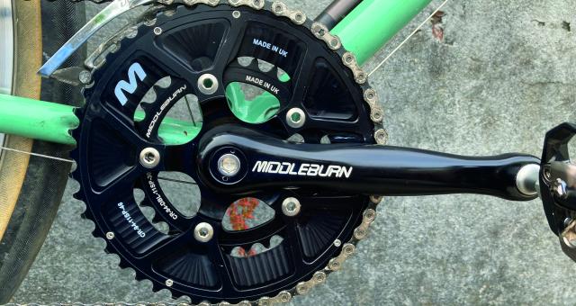 The black chainset and crank of a bicycle