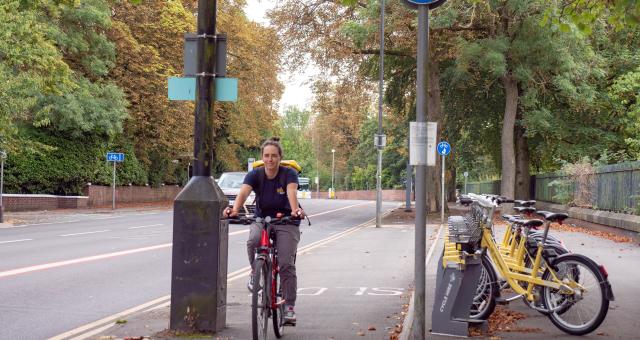 woman cycling towards camera in city cycle lane