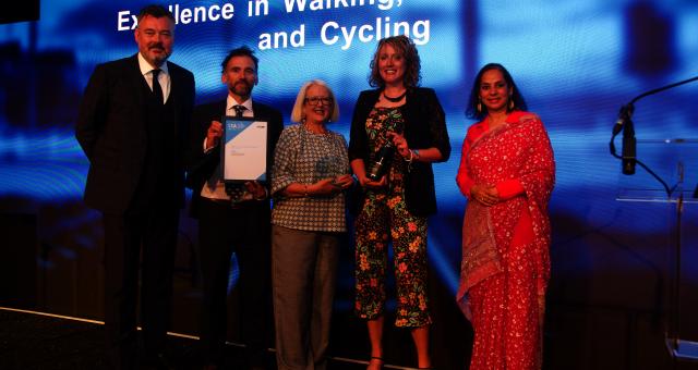 Anna Vince from Cycling UK and representatives from Aberdeenshire Council standing on stand being presented with an award