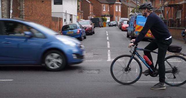 A cyclist negotiating a right turn at a junction.
