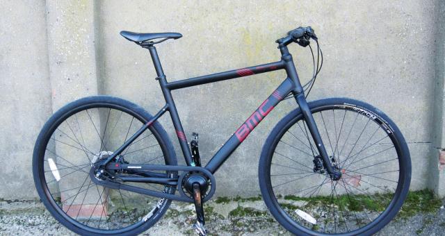 The BMC Alpenchallenge AC02 Nexus, a black city hybrid bike with flat bars and no rack or mudguards