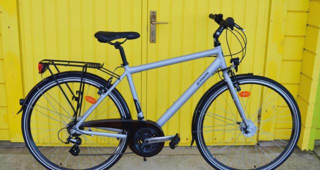 B’Twin Hoprider 300 City, a grey hybrid bike with flat bar, mudguards and rear rack