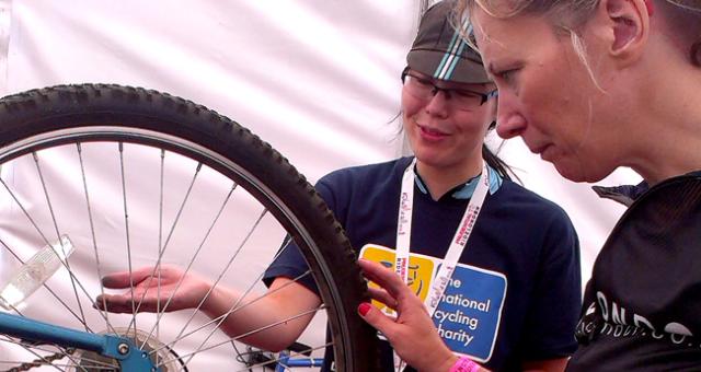 A Dr Bike volunteer fixing a participant's cycle