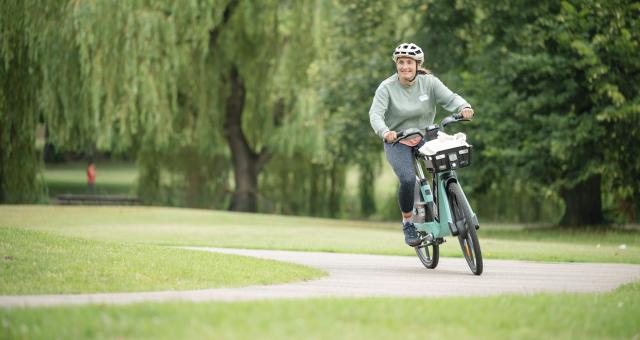 Woman pedals Making cycling e-asier TIER e-cycle through park in Luton