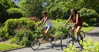 Two women cycling on a path out in the sun ©Joolze_Dymond