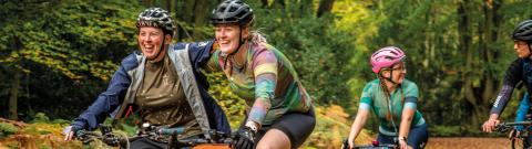 People in a forest, on gravel bikes smiling