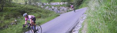 Two cyclists on the road cycling through Cheddar Gorge (c) Chase the Sun