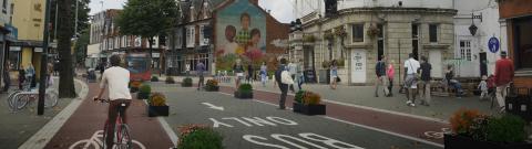 Town city centre scene with people walking and people using a cycle lane