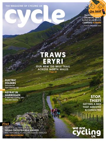 The front cover of Cycle magazine's August/September 23 issue featuring a group of people cycling on a gravel path through Welsh mountains