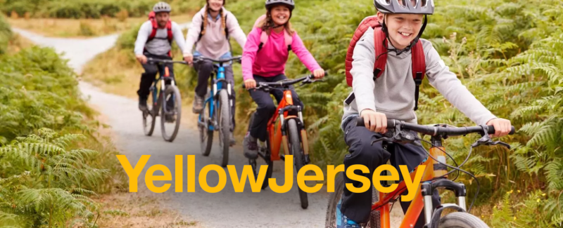 Children cycling in a line outside on a grey path with the yellow jersey logo overlay