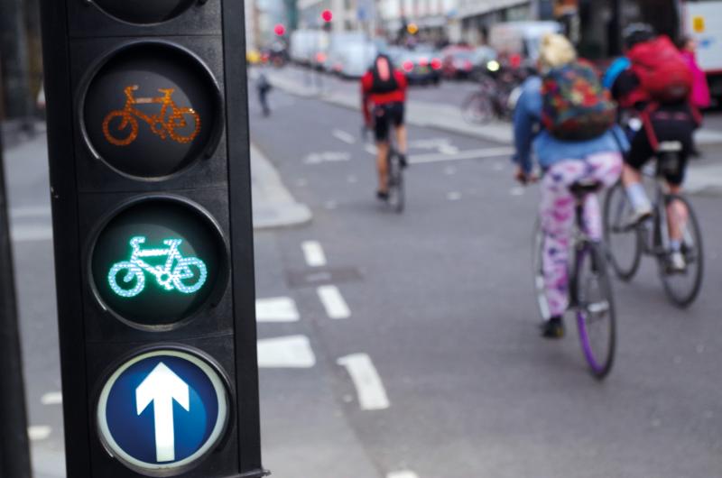 Cycling traffic lights currently showing a green light with cyclists in the background (c) Adrian Wills